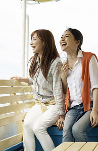 两个女生坐在船上微笑看风景图片