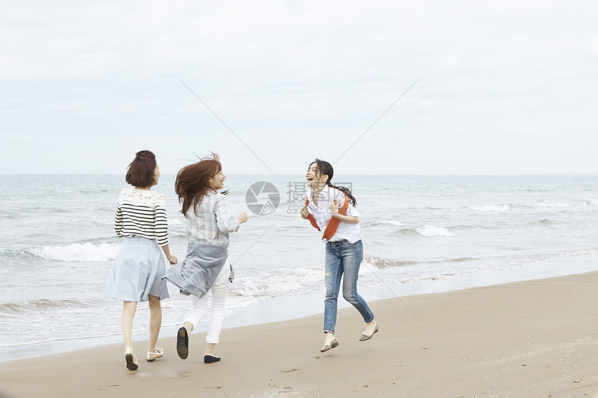 三个女生在海边开心享受旅行图片