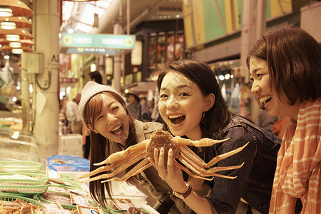 抓螃蟹的女孩妇女在生猛海鲜观光市场挑选螃蟹背景