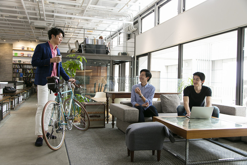 推着自行车的商务人士在和同事交流图片