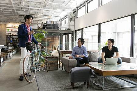 推着自行车和同事沟通交流的商务男士图片