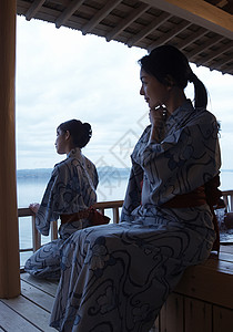 坐在温泉会馆外部露天池穿浴衣的两个女生背景图片