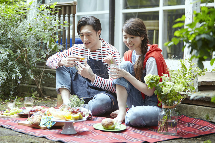 年轻情侣在户外野餐享受美食图片