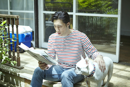 男人坐在台阶上轻抚着狗阅读图片