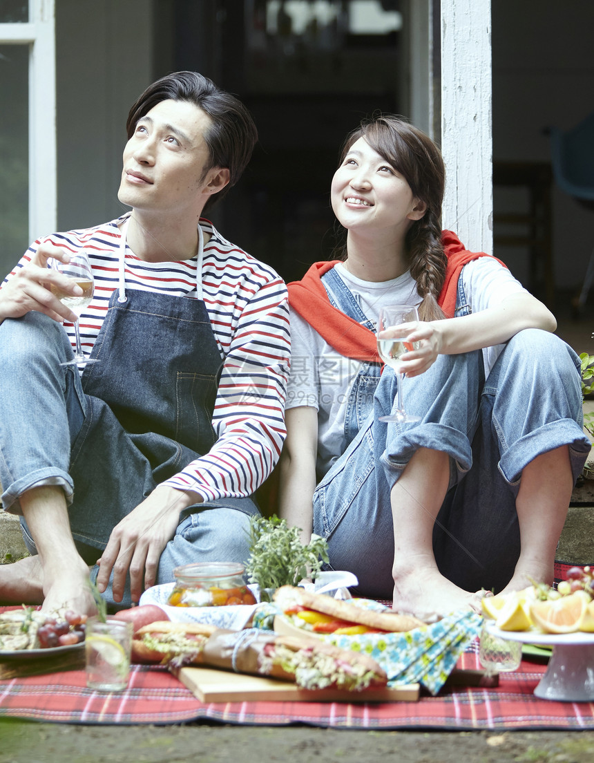 在户外野餐享受美食的年轻夫妻图片