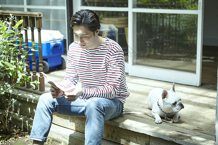 年轻男性与宠物在屋外玩耍图片