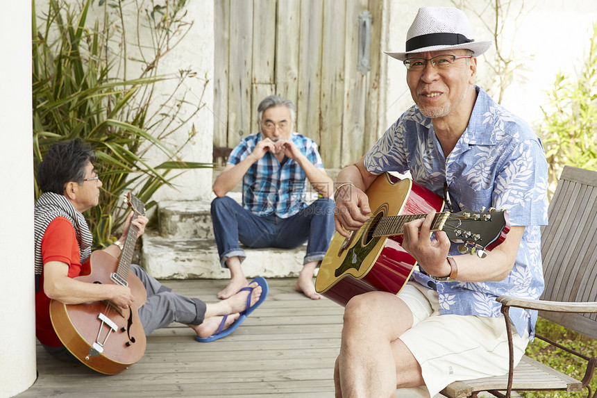 60多岁爱好音乐的三个年长男性在户外聚会享受音乐图片