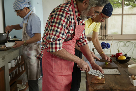 厨房烹饪食物的老年男性背景图片