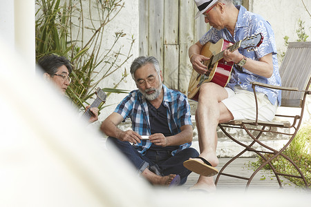 音乐人生三位年长男子一起享受音乐弹吉他背景
