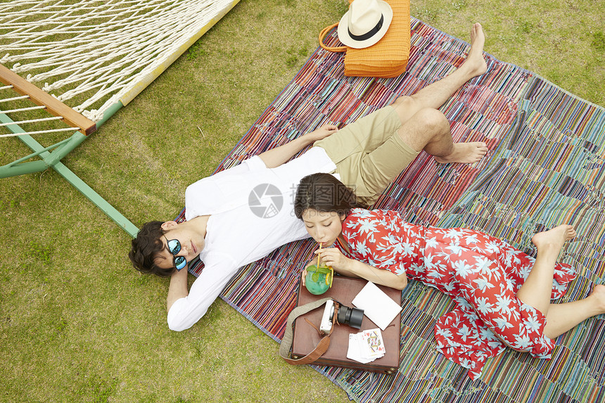 年轻情侣度假约会在野餐垫上休息图片