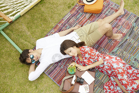 年轻夫妻酒店度假草坪垫子上休息图片