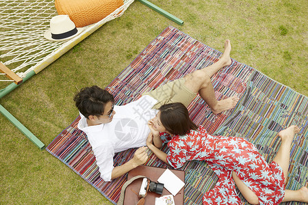 躺在野餐垫上休息的年轻夫妻图片