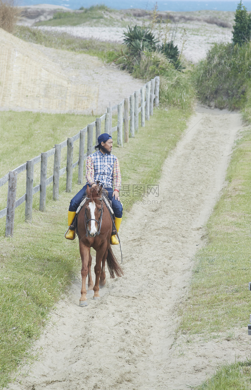 草原牧场骑马的男人图片
