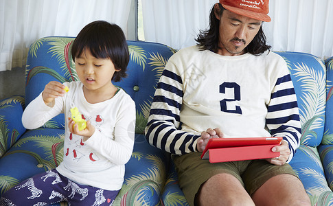 男孩与父亲在露营车中玩肥皂泡图片