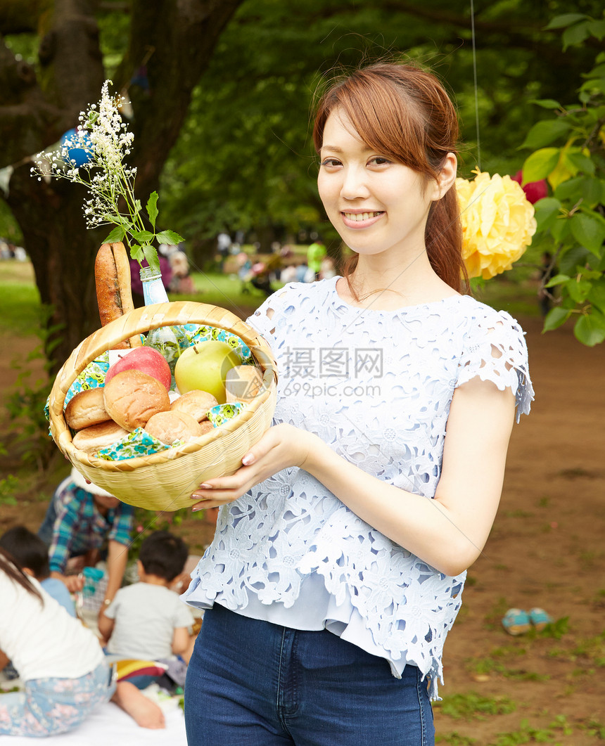 展示野餐篮里苹果的女人图片