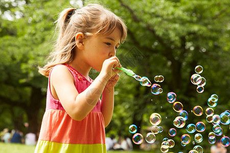 汽球草地玩肥皂泡泡的小女孩背景
