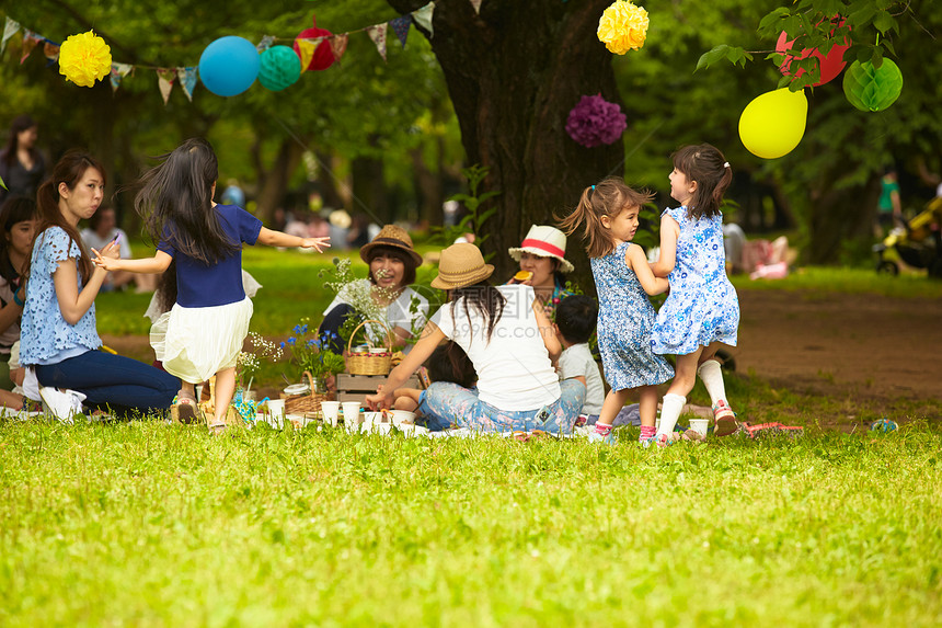 妈妈们带着孩子一起在公园享受野餐图片