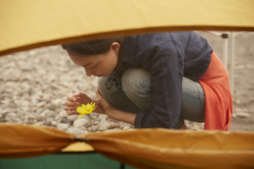 帐篷外欣赏花朵的女人肖像图片