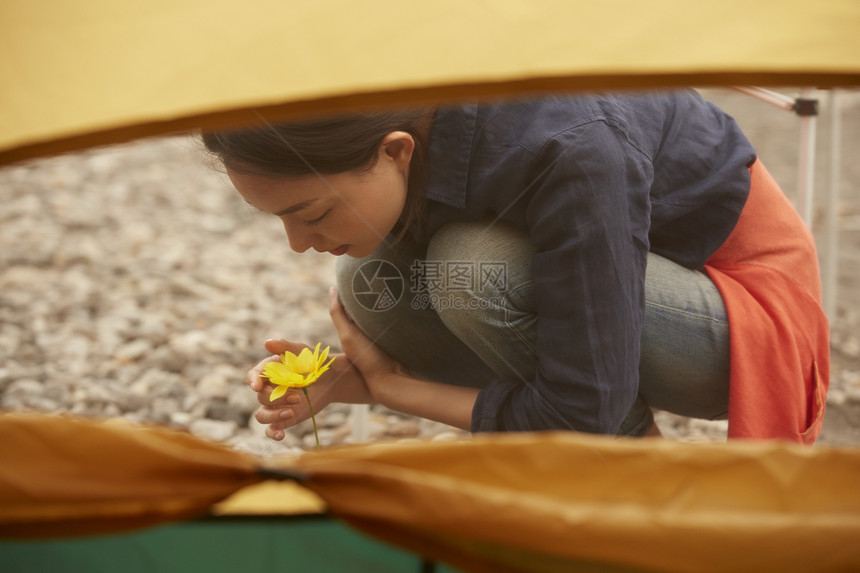 帐篷外欣赏花朵的女人肖像图片