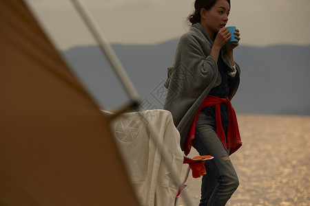 湖边拿着水杯独自旅行的女生肖像图片