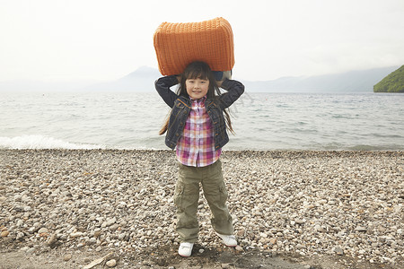 湖边举着包的女孩肖像图片
