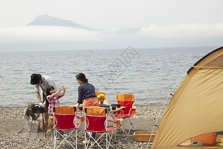 暑假湖边露营烧烤的四口家庭图片