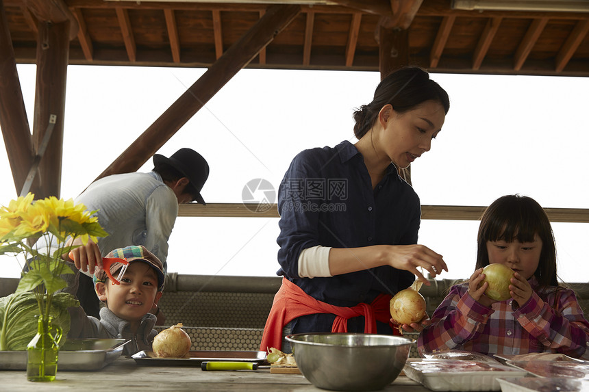 准备家庭营地食物的四口之家图片