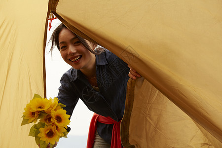 帐篷外开心拿着花束的女生肖像图片