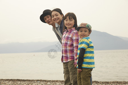 湖边旅游的四口之家全家福图片