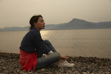 湖边独自坐着的女生肖像图片
