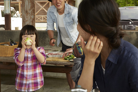 准备家庭营地食物的女孩与父母图片