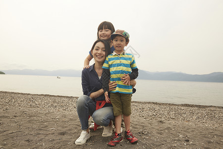 假期湖边玩耍的母亲与孩子们的全家福图片