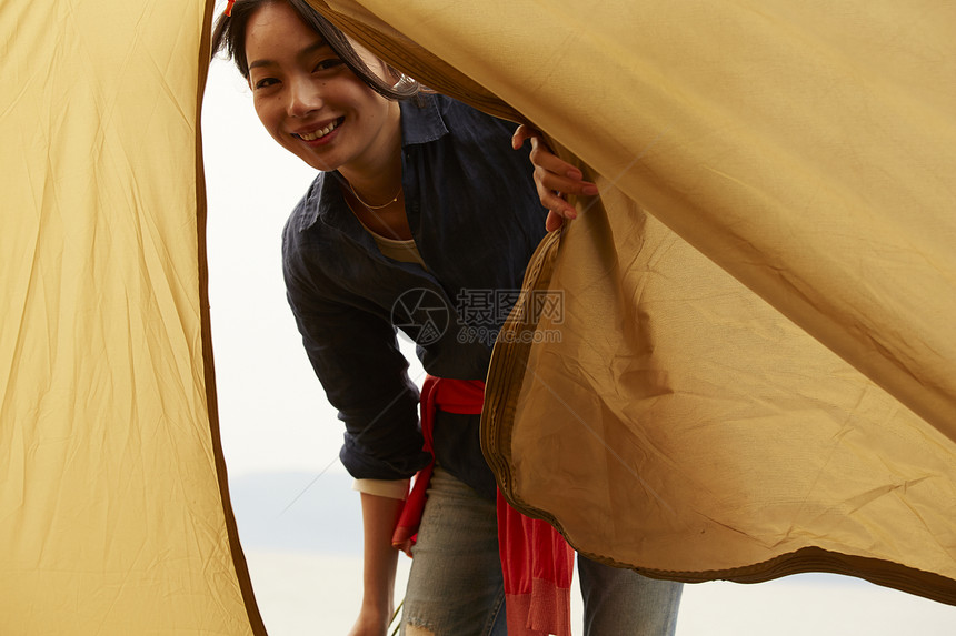 微笑掀开帐篷帘的女人图片