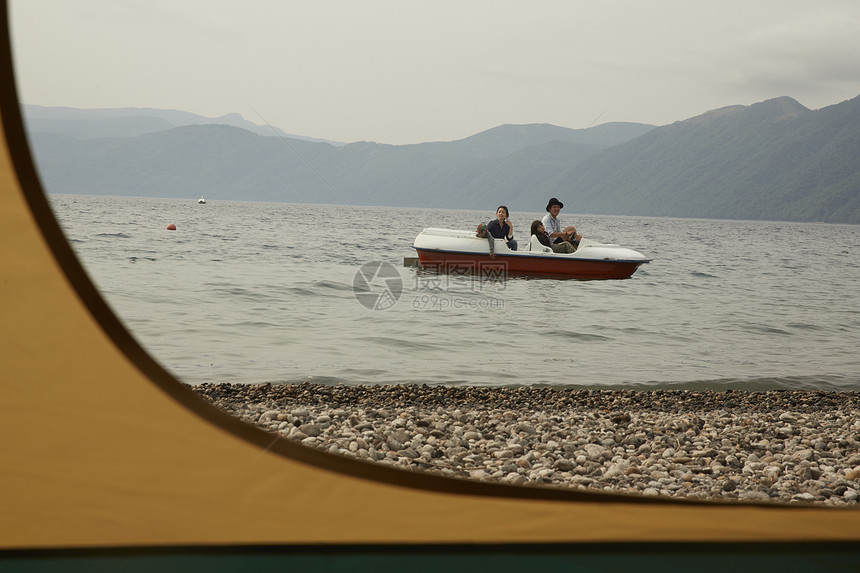 帐篷外坐脚踏船的4人图片
