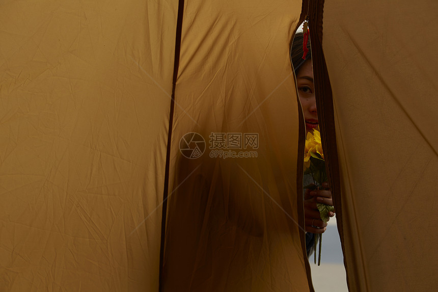 黄昏捧着花站在帐篷外的女人图片