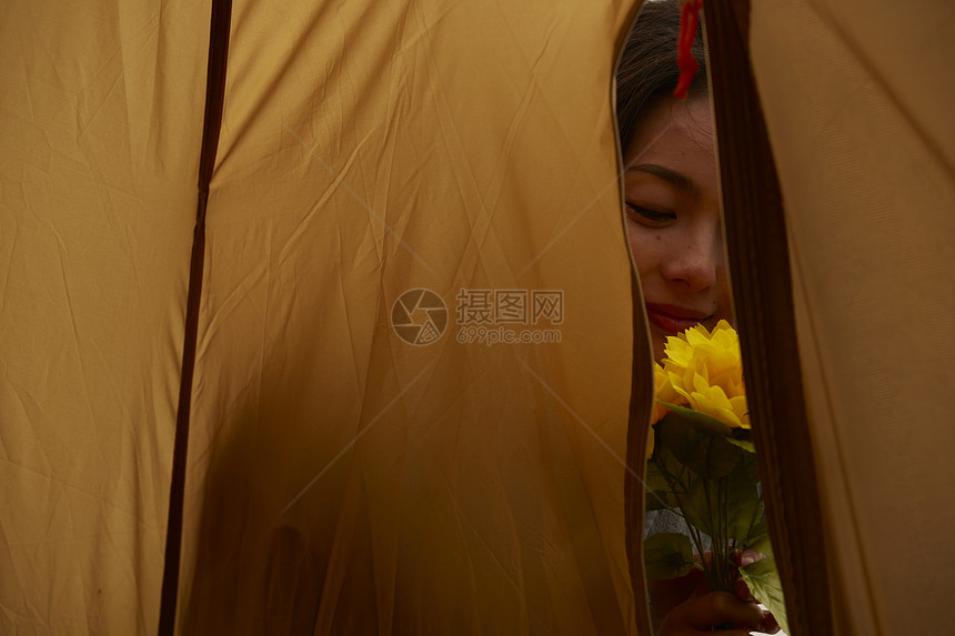 在帐篷外的女人拿着花图片