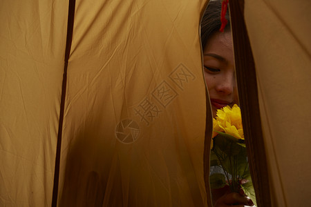 在帐篷外的女人拿着花图片