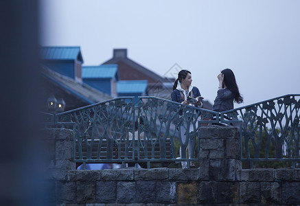 在桥上两个女生带着相机结伴旅游图片