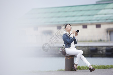 游客女人海边观光拍照图片