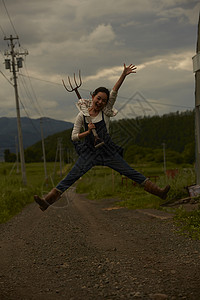 欢蹦乐跳菜地里跳跃的农民女青年背景