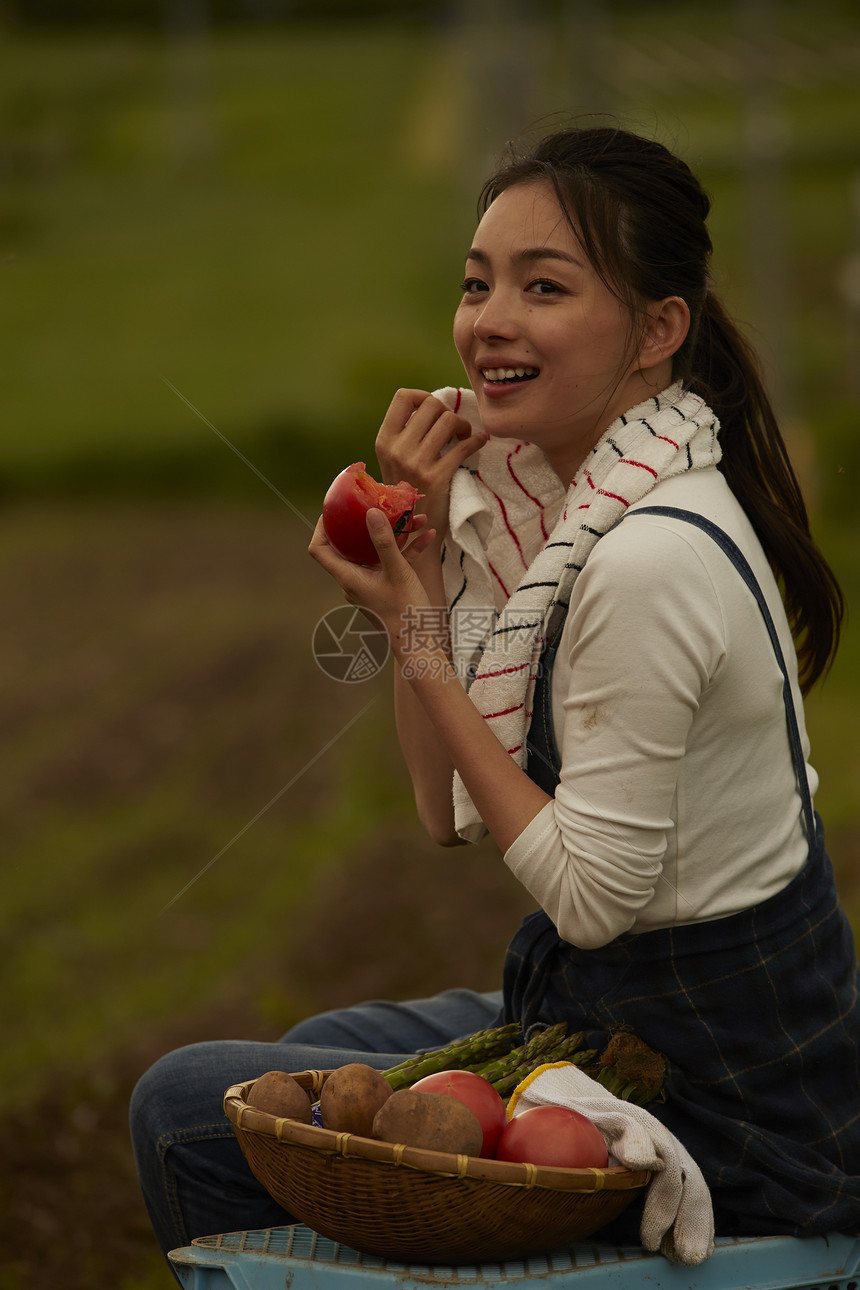 吃新鲜番茄的女青年图片