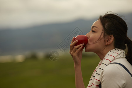 户外吃苹果的女士图片