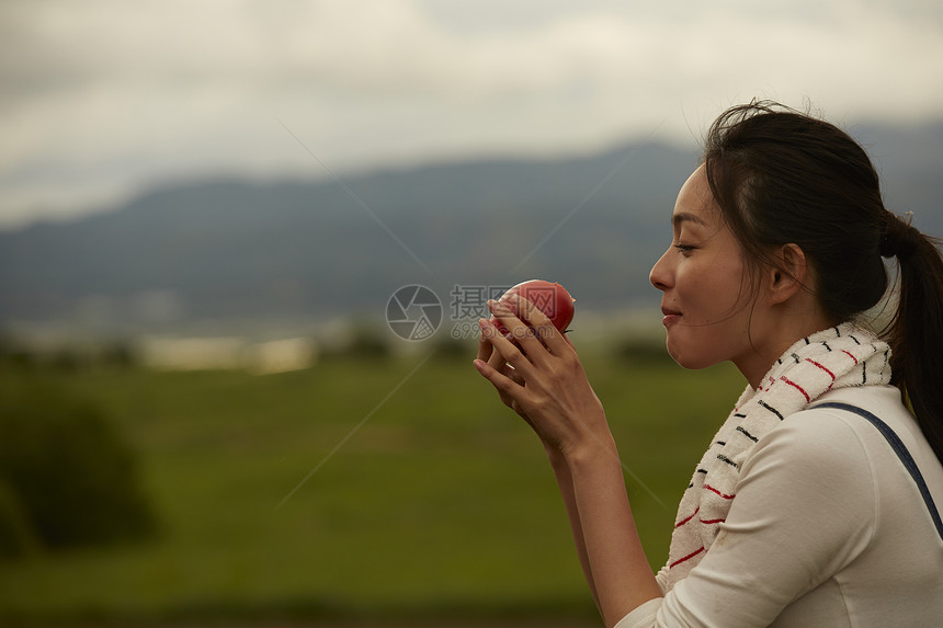 农田旁吃农产品的女孩画像图片
