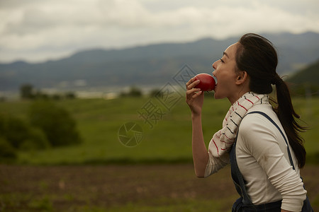 农田旁吃农产品的女孩画像图片