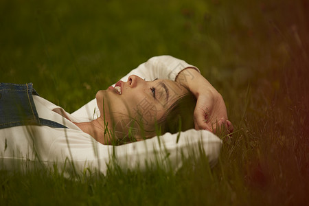 女人躺在草地上休息图片