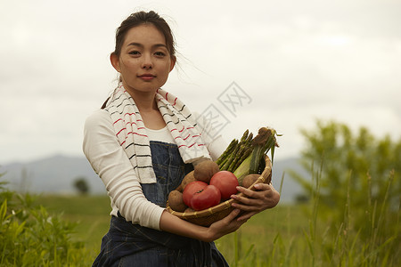 田间拿着农作物的农业女孩画像图片