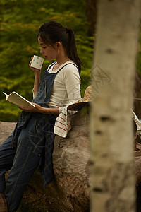 靠着农场大树喝茶看书的农业女孩画像图片