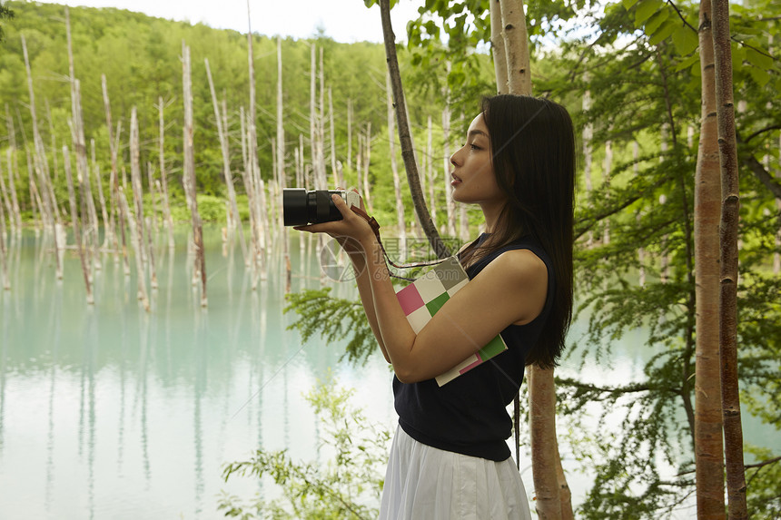 一个独自旅行的女人拿着相机图片