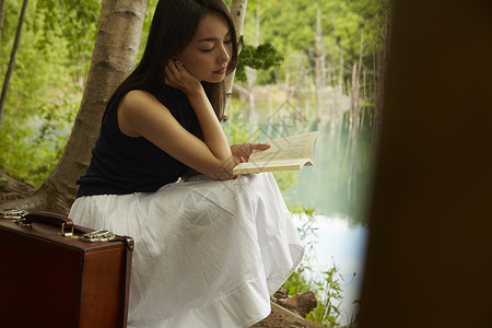 在湖边独自看书欣赏风景的女人图片