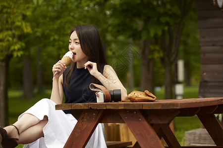 女孩在室外吃奶油冰激凌图片